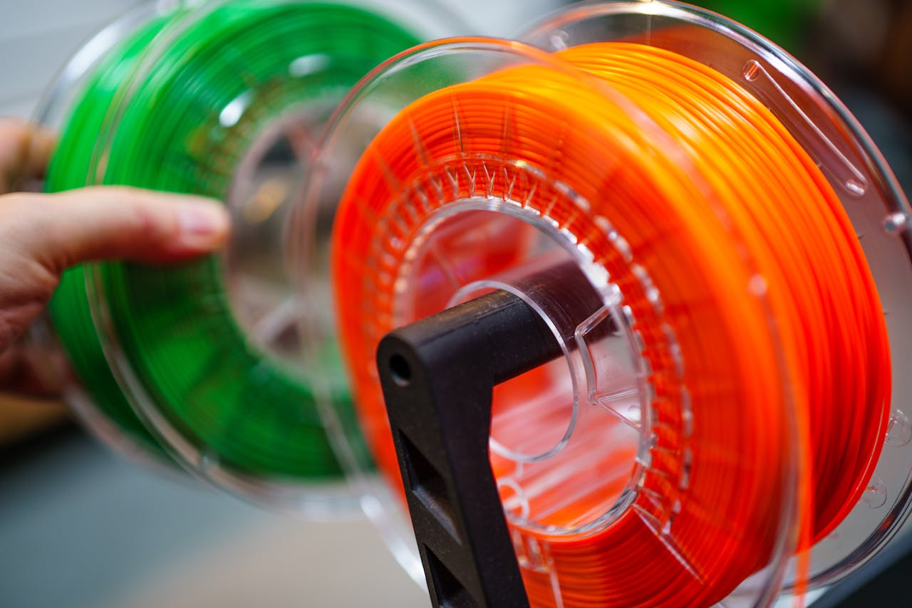The Art of Drawing Readers In: Your attractive post title goes here Vibrant orange and green 3D printer filament spools for innovative manufacturing uses.